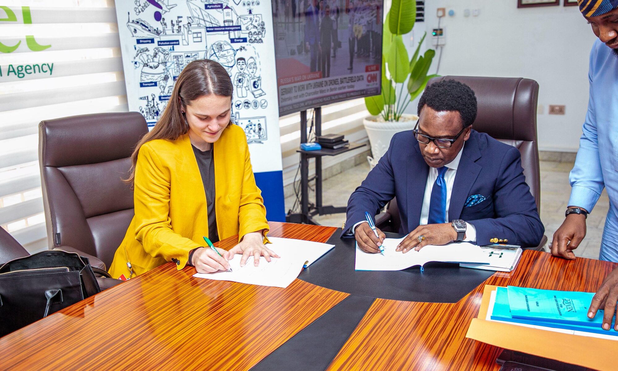 Man and woman sign documents at conference table